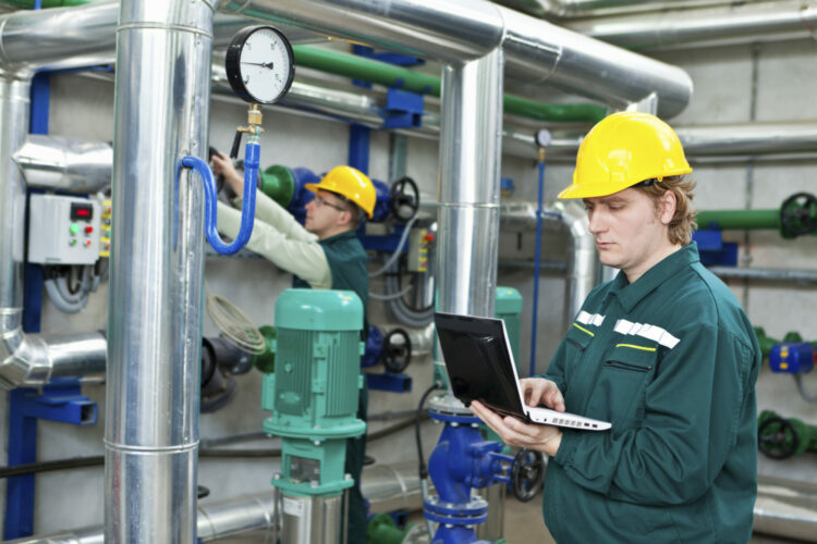 Two man working in a factory, controls the operation of devices in a Heating Plant or Refinery. Please see my other photo and videos with the same theme.